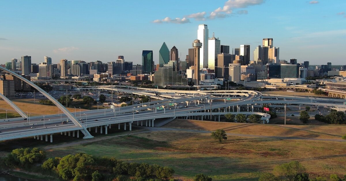 The Dallas city skyline as seen from afar, with plenty of land to invest in in the foreground