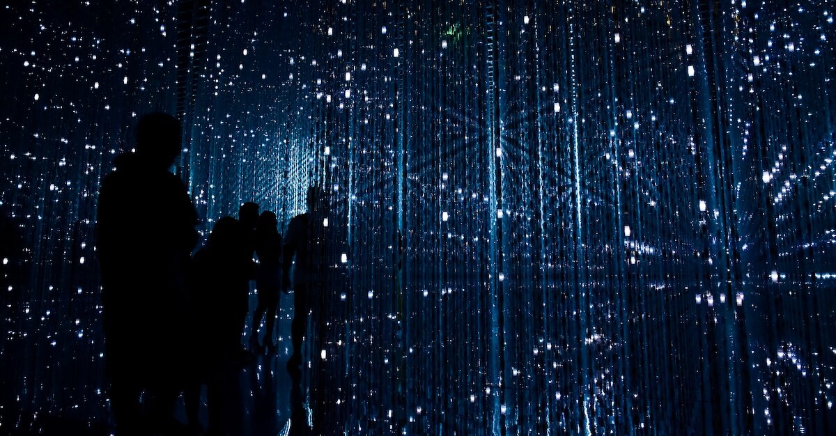 A constellation-looking room of tech servers and technology, with people walking around inside