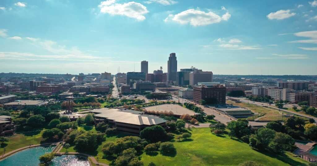 Loads of parks, greenery, and some multifamily buildings in the foreground with the skyline of Omaha in the back