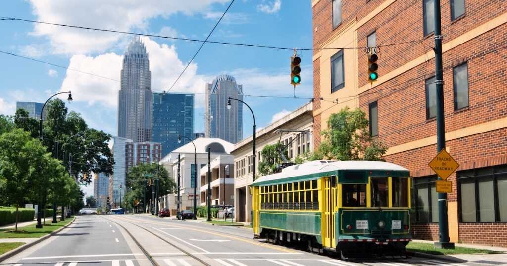 Charlotte's green trolley rolls by some office buildings