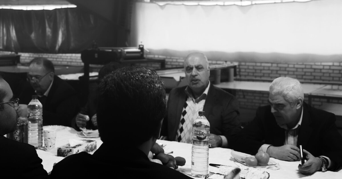 Sitting at a restaurant table, a group of men are discussing business negotiations
