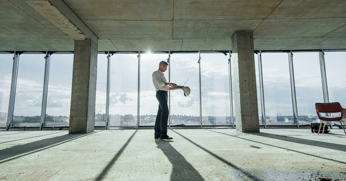 A CRE investor in an empty office building he's evaluating for investment value
