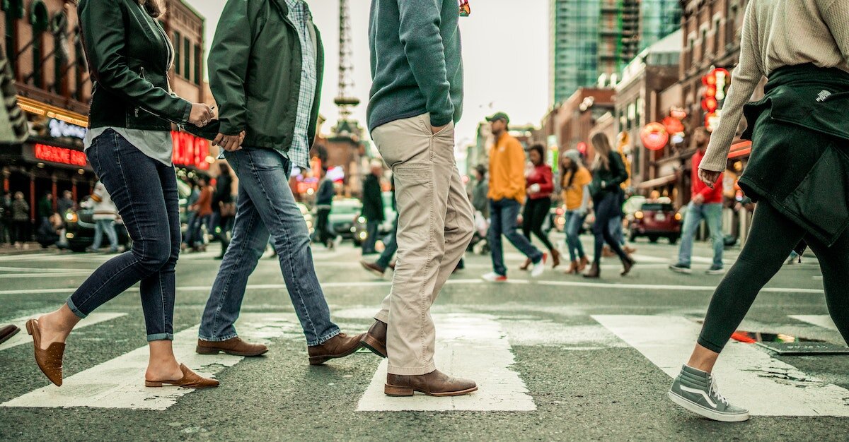 People crossing the street in a busy intersection.

