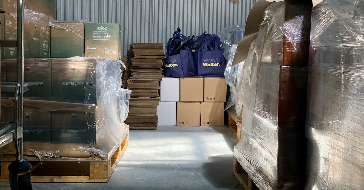 the inside of an industrial storage unit with plastic-wrapped boxes stacked in piles