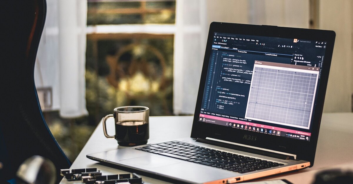 a laptop with lines of code and graphs on the screen