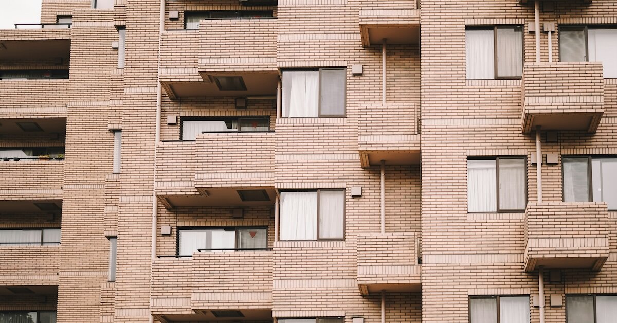 Brickface multifamily building with balconies outside the windows