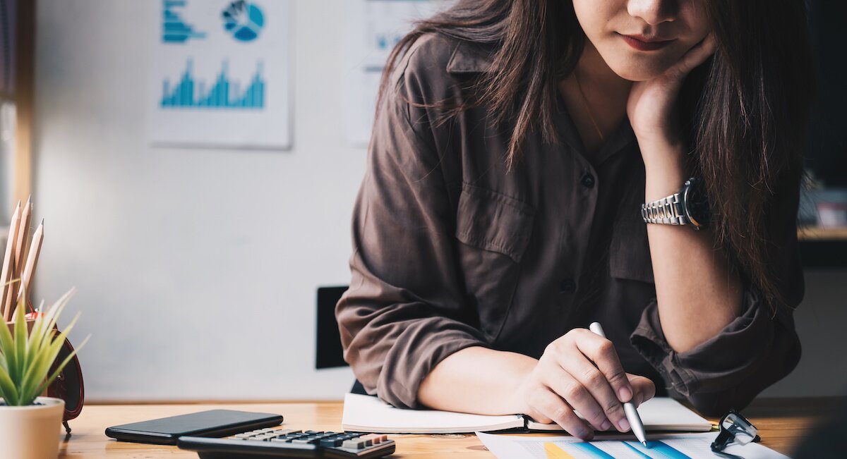Business woman using calculator for do math finance on wooden desk in office and business working background, tax, accounting, statistics and analytic research concept