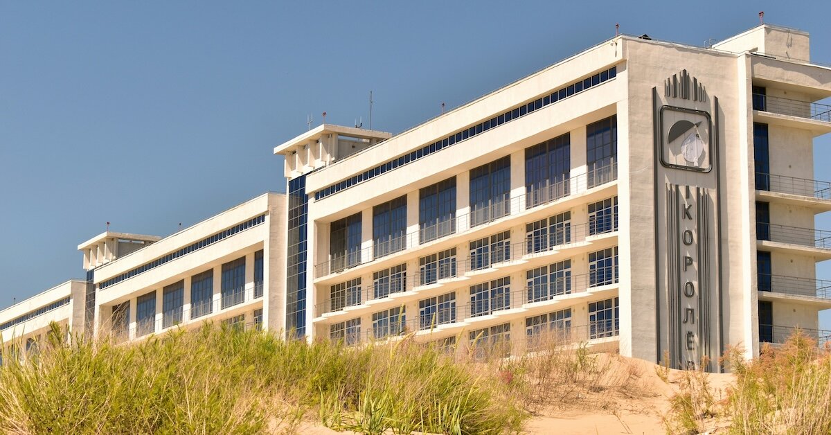 Hotel buildings alongside sandy dunes next to a beach