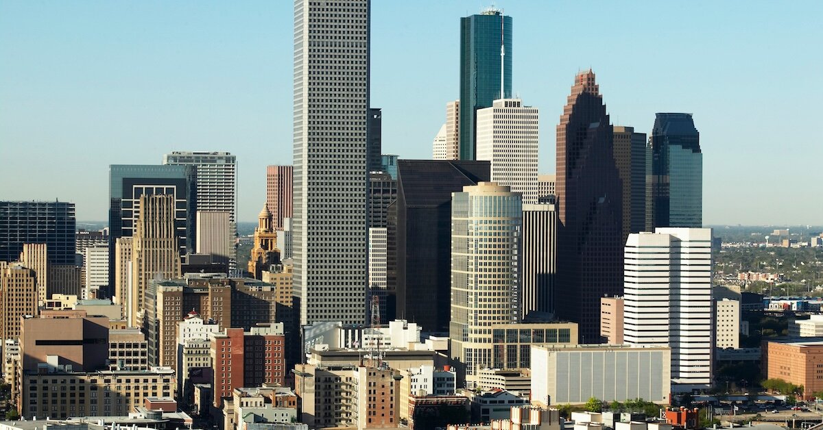 A daytime view of tall Houston buildings and surrounding commercial property in the city.