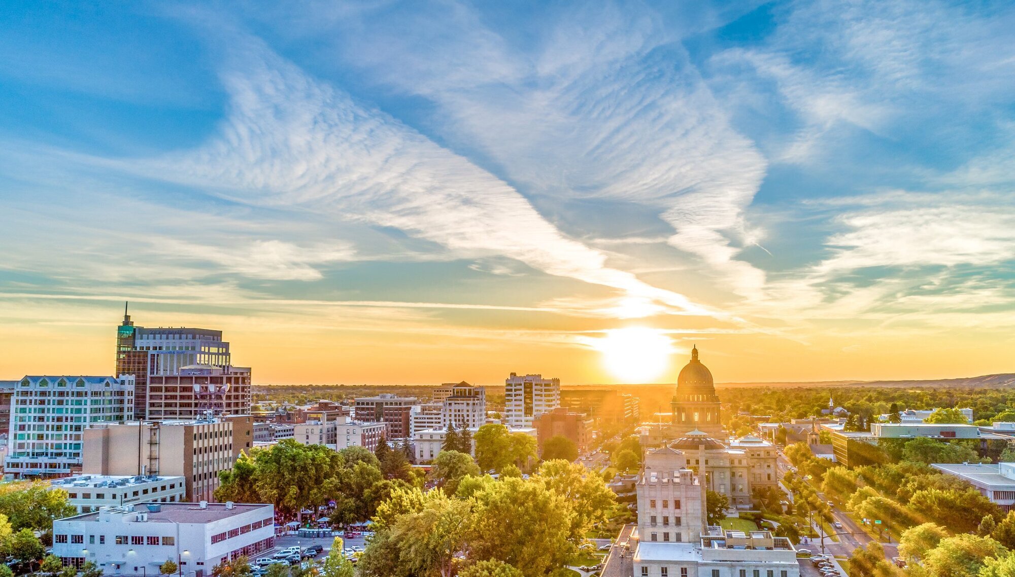 The town of Boise, Idaho, with the sun setting behind it. 