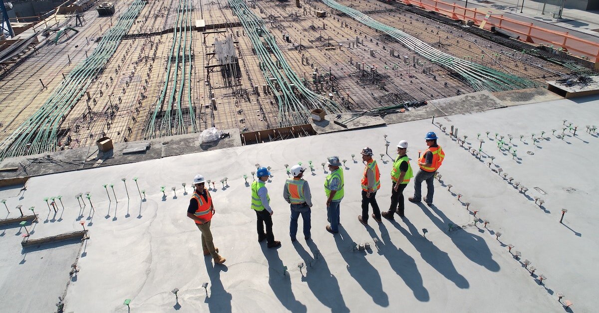 Construction workers survey a construction site.