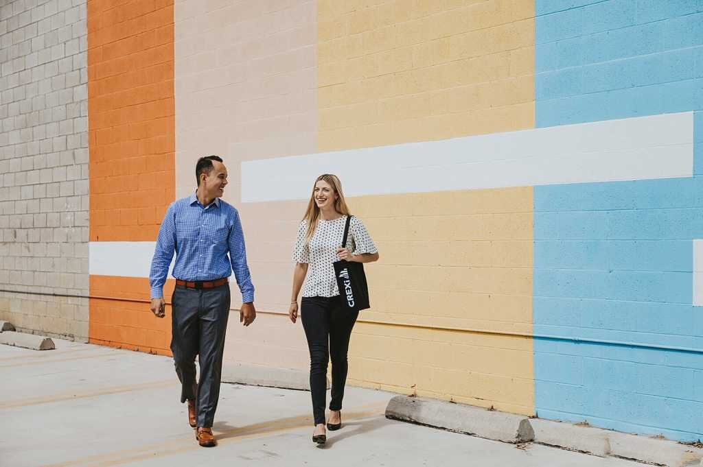 Two people walking through an outdoor parking lot in conversation