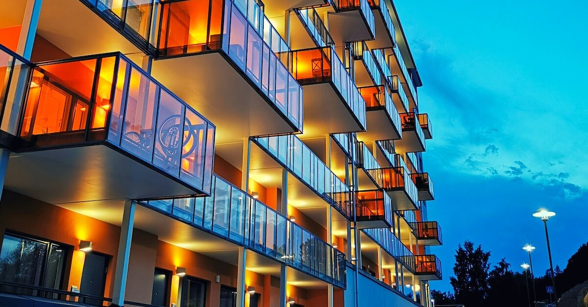 Lit up apartment buildings with bicycles and other decoration on their porches