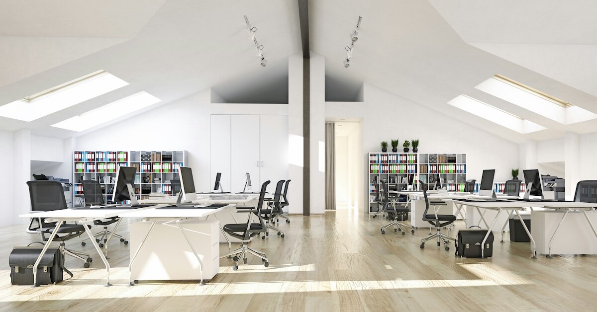 The inside of an office building with open desks and floor space and various computer workstations