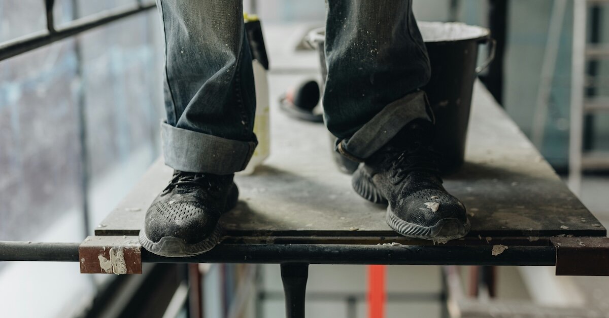 A construction worker standing on a lift on a commercial property redevelopment site
