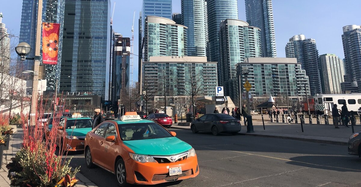 A colorful taxi in the foreground of a city