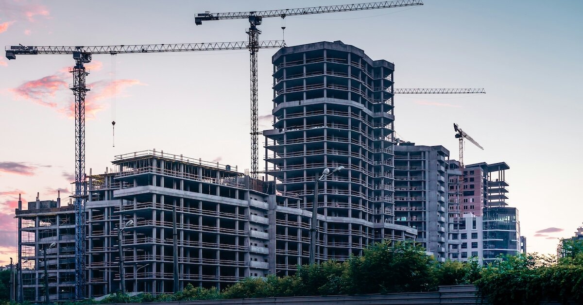 A construction site building a new large office building at sunset