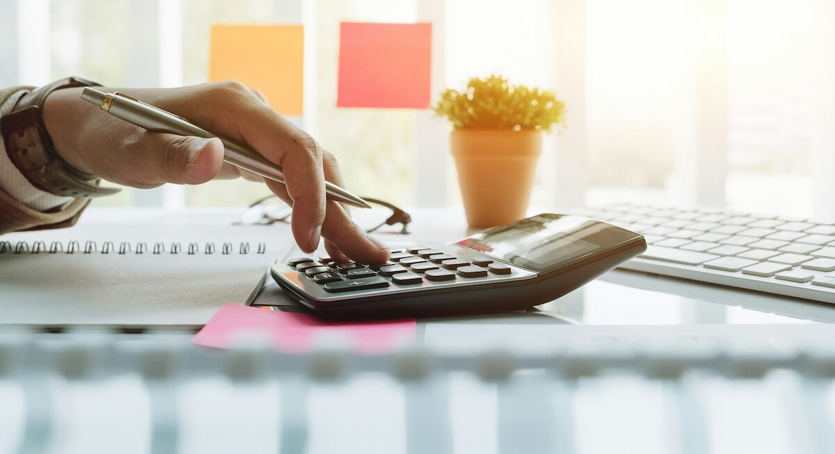A woman uses a calculator to compute a math problem