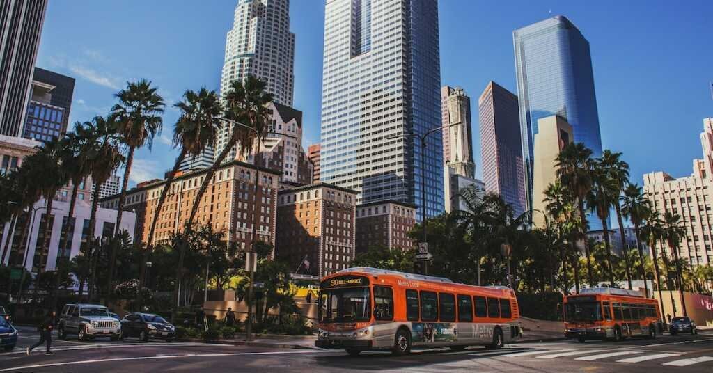 A red bus drives on a downtown street near Pershing Square in downtown Lois Angeles