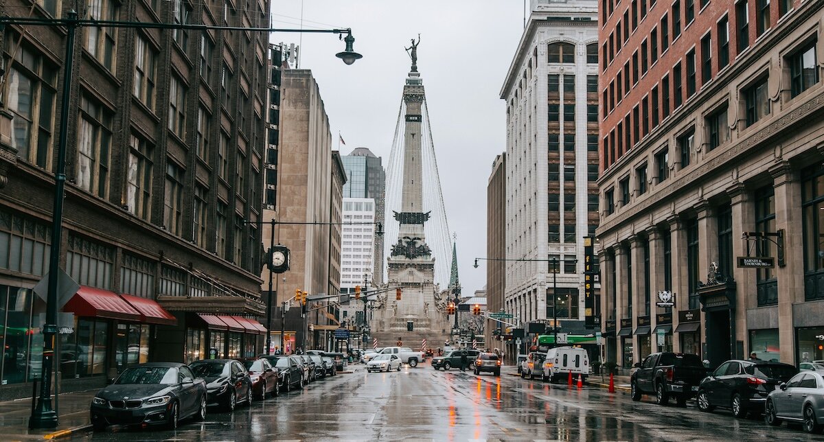 Retail shops and skyscraper buildings framing a road in the central business district of Indianapolis