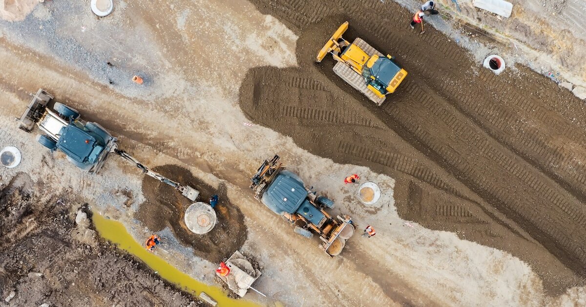 An overhead shot of construction vehicles in a development lot