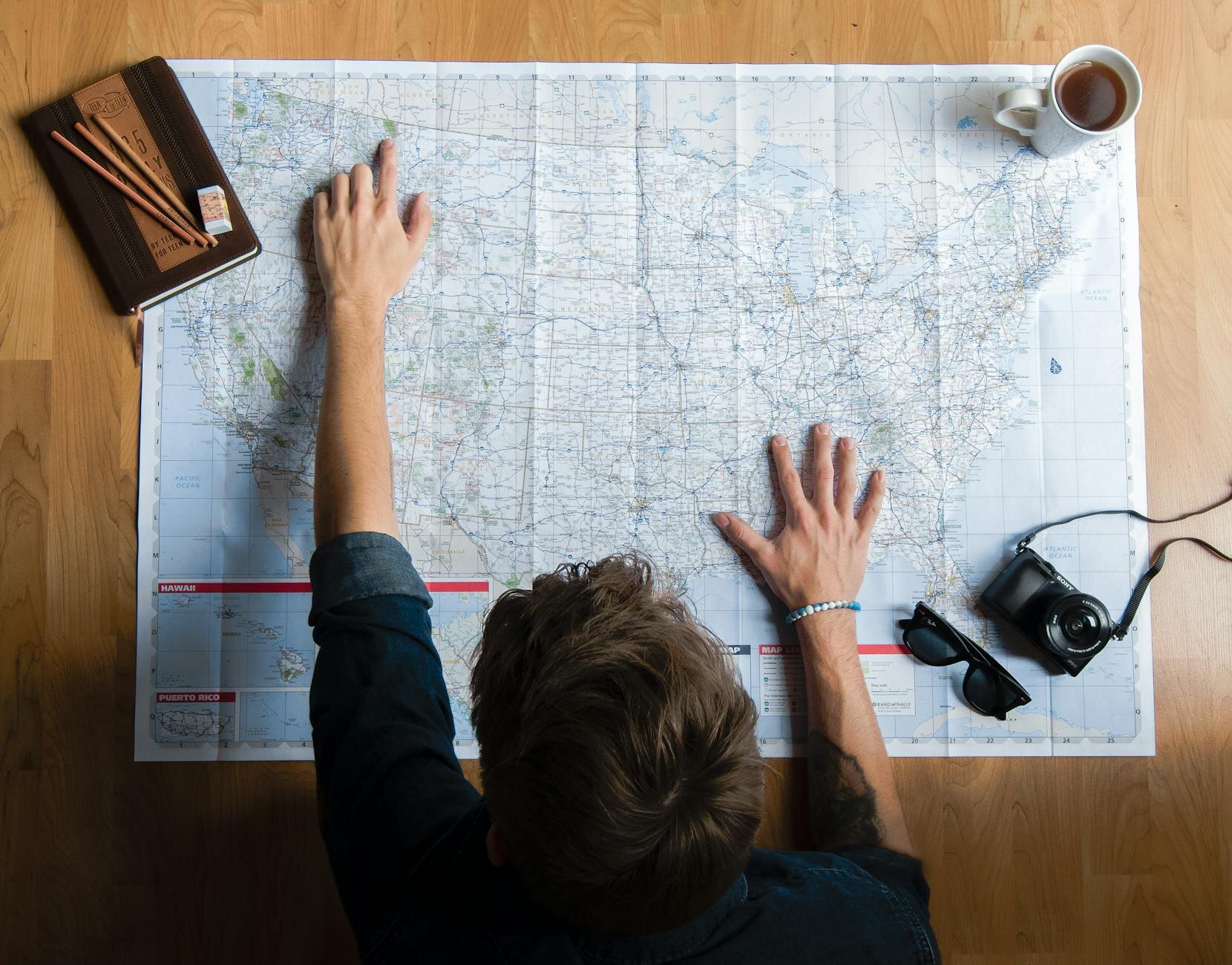 man looking at a map of the U.S. and pointing to a location