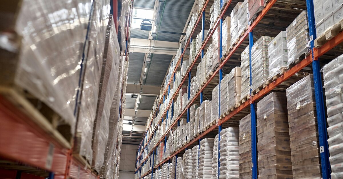 The inside of a packed warehouse with stacked packages wrapped in plastic