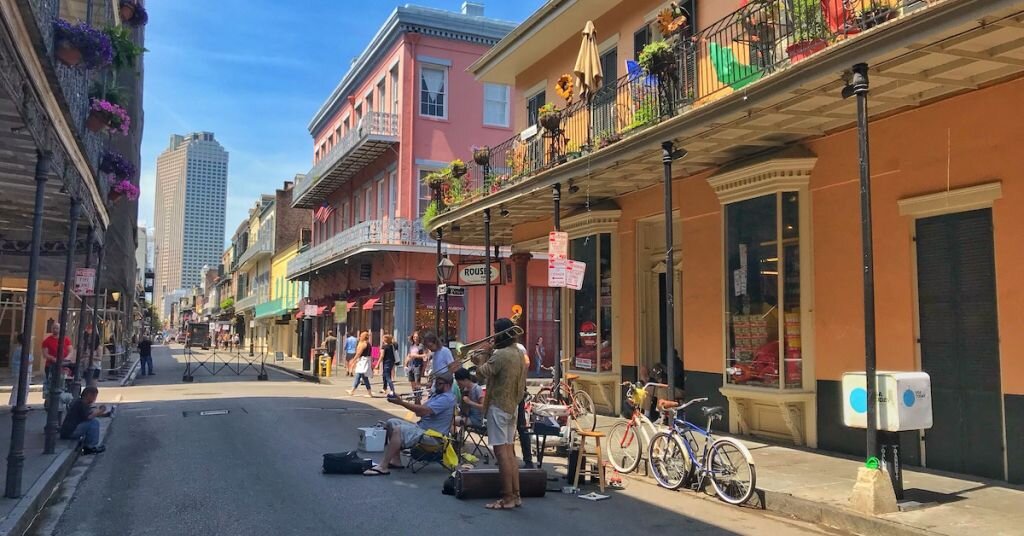 A street band plays in New Orleans' French Quarter during the day, as pedestrians walk by