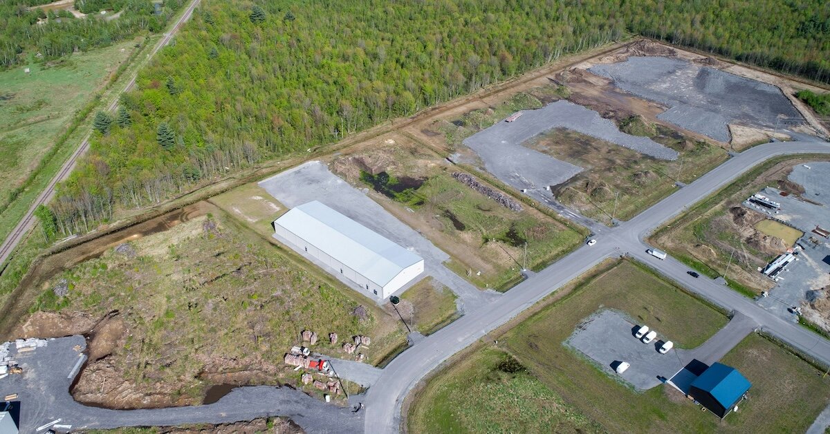 A drone shot of land and warehouse buildings