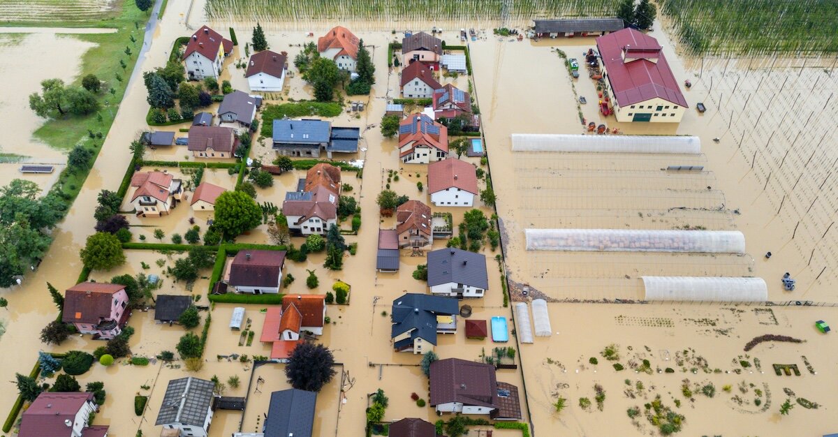 high water levels surrounded several houses with mud and debris