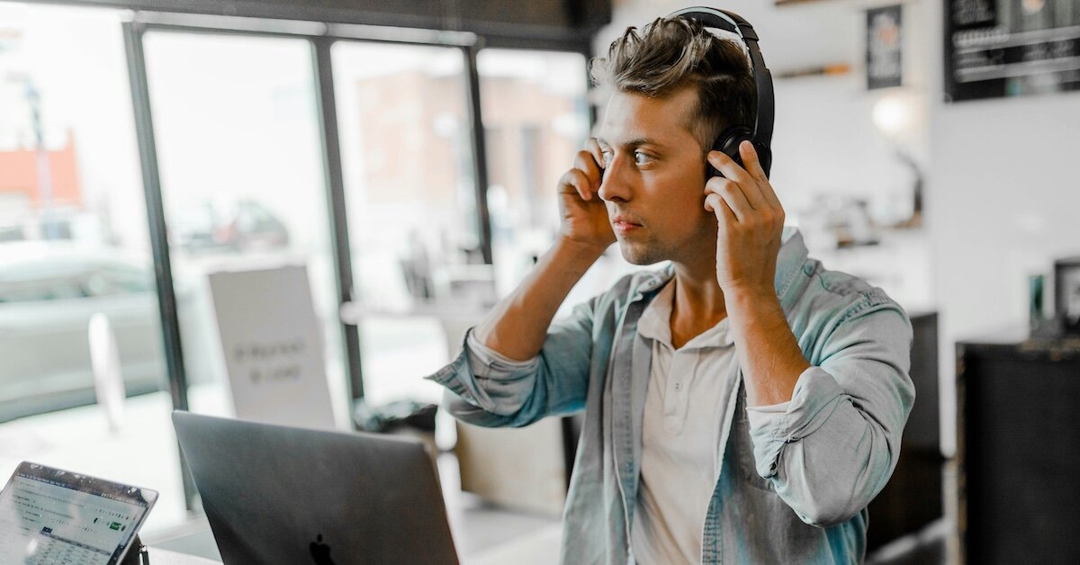 A young broker puts his phone headset on before starting cold calls