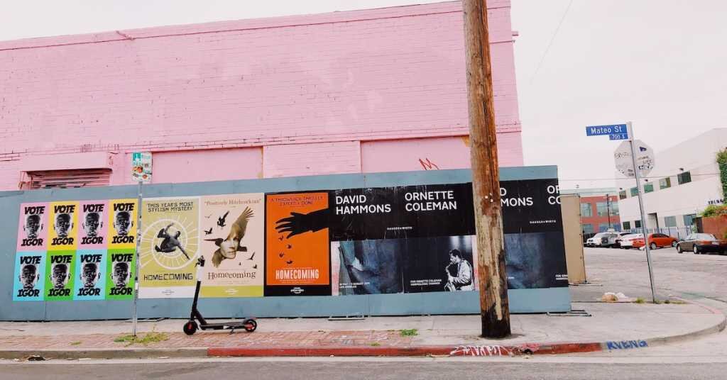 Pink wall with construction wall ads for Tyler the Creator and the Homecoming film
