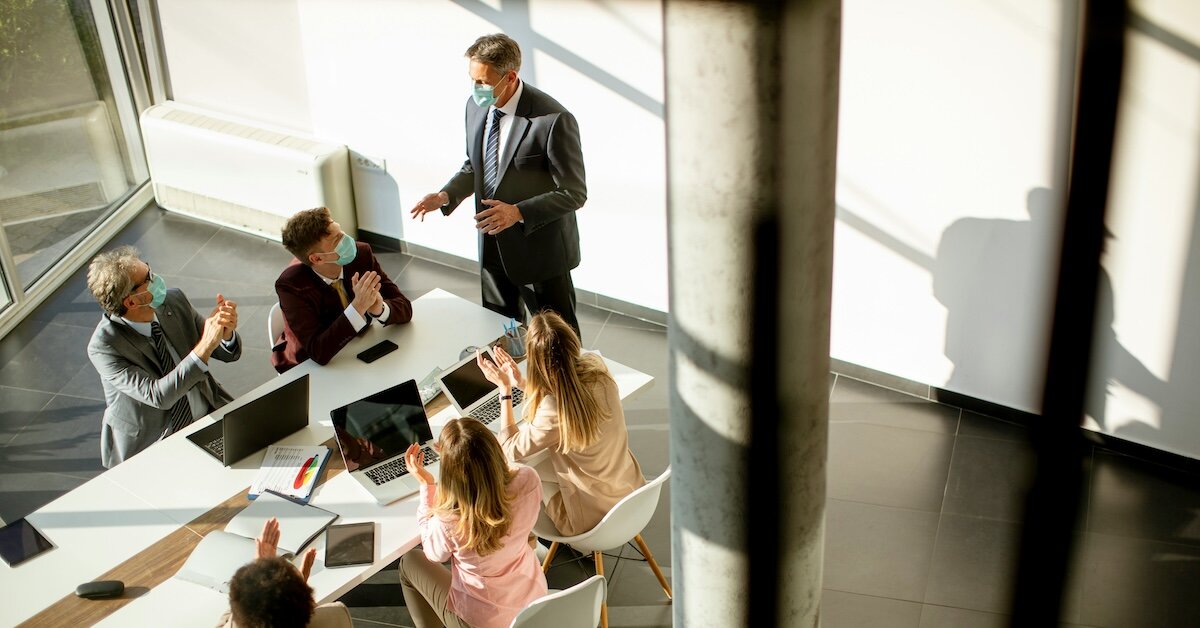a team of brokers go over project updates in a conference room office