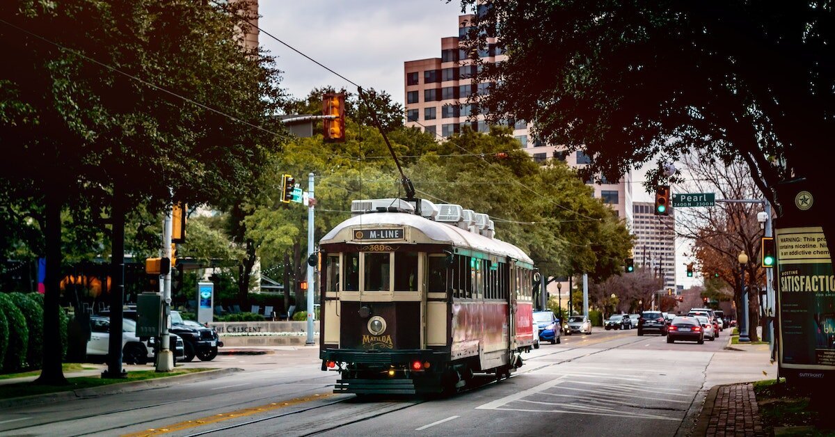 A trolly rolling through Downtown Dallas around its offices