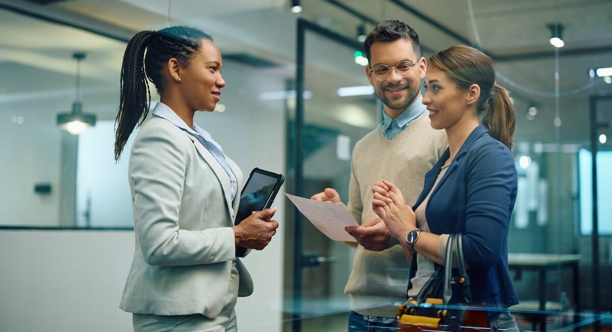 Three business professionals in conversation in a commercial office