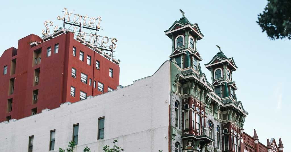A red hotel with vintage townhouses in front.