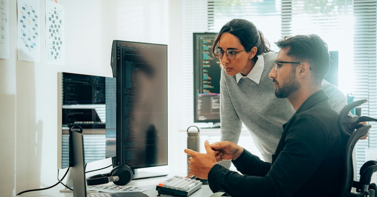 two individuals review the output of an AI research request on the computer