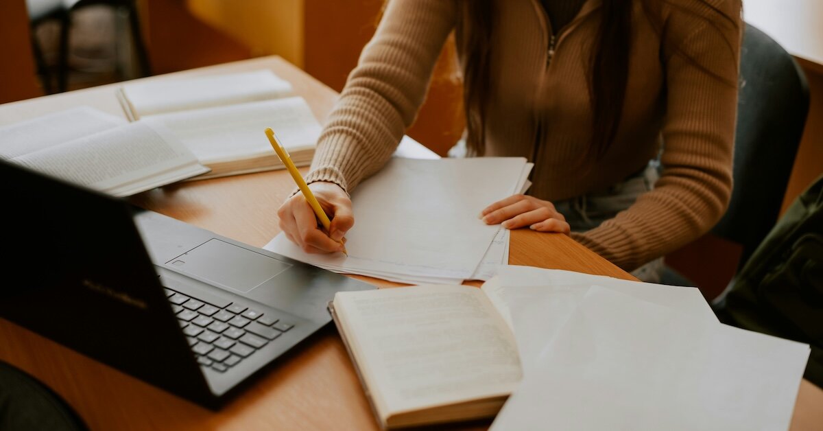 A woman using parcel data written down on her notes with her laptop in front of her