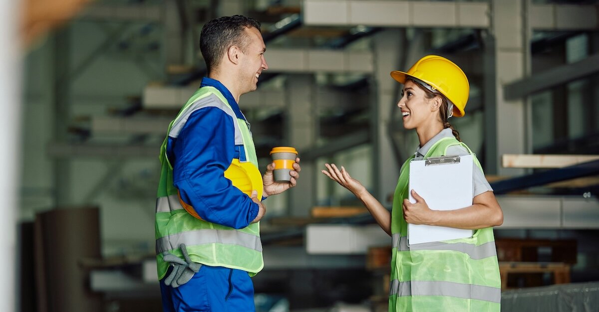 Two professionals discussing logistics on a multifamily construction site