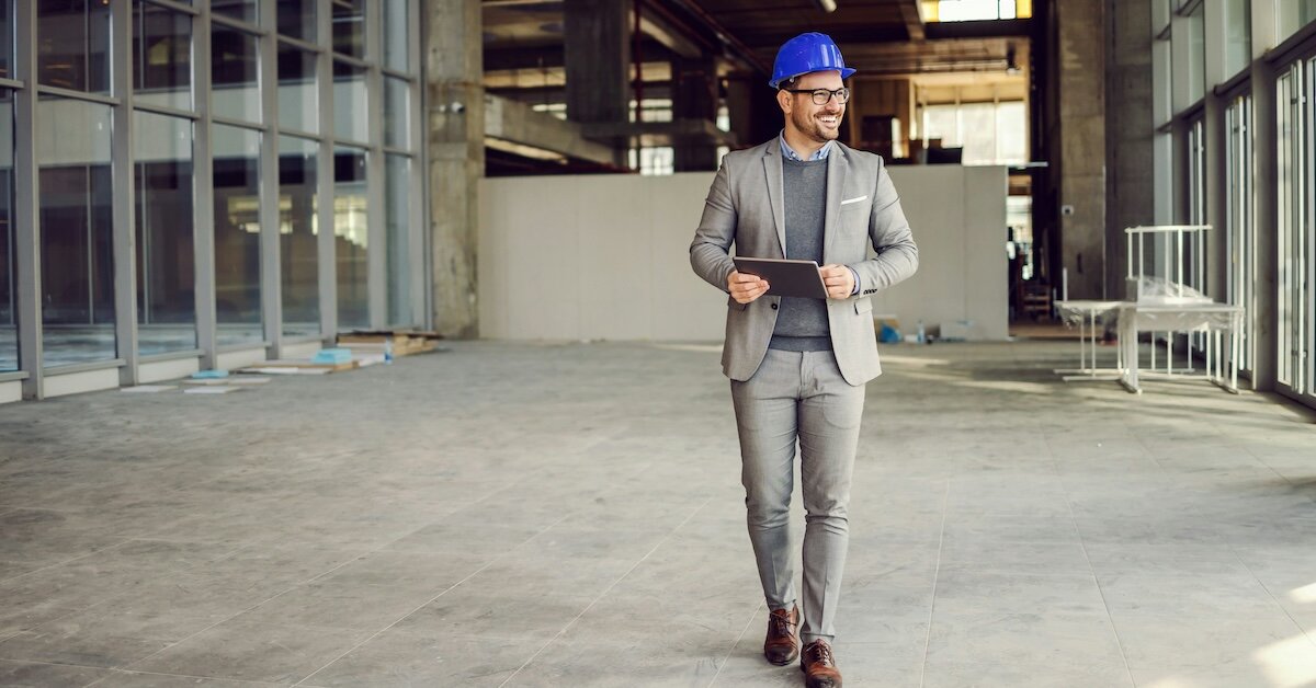 a broker walking an empty office building holding an ipad