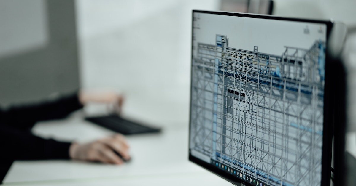 Someone working on a computer with a 3D scaffolding model up on sceen.