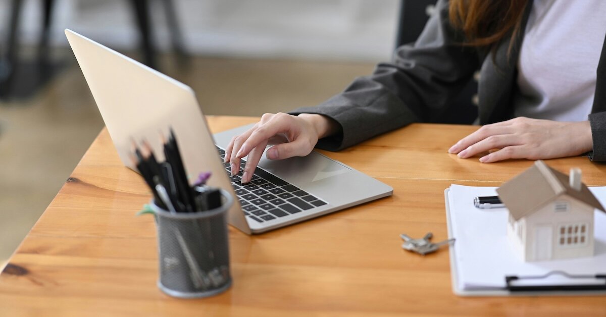 a woman checks information on loan documents on her laptop