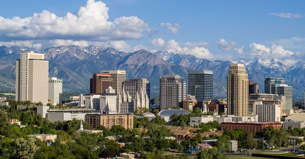 The downtown city skyline of Denver stands against its nearby western mountains.