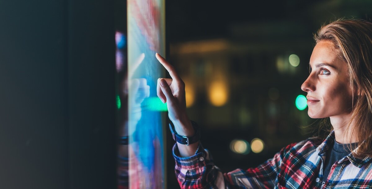 A women touching a screen in an office