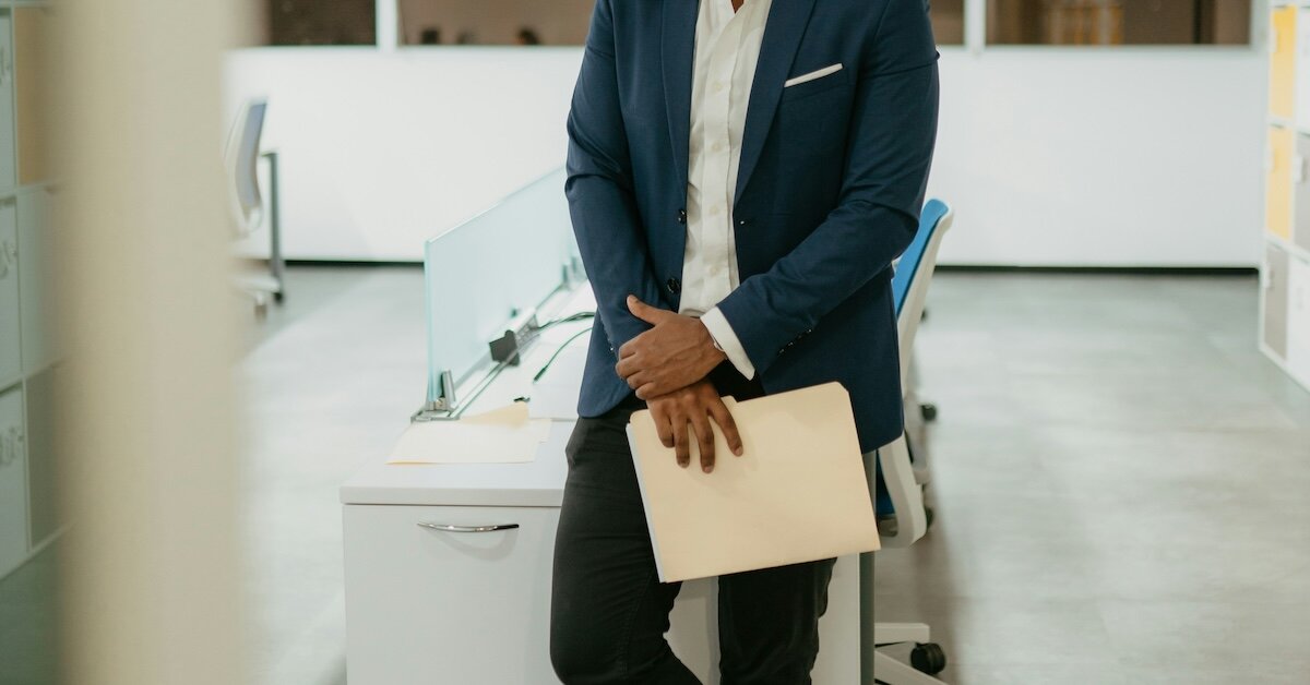 man waiting in an office holding a manila folder