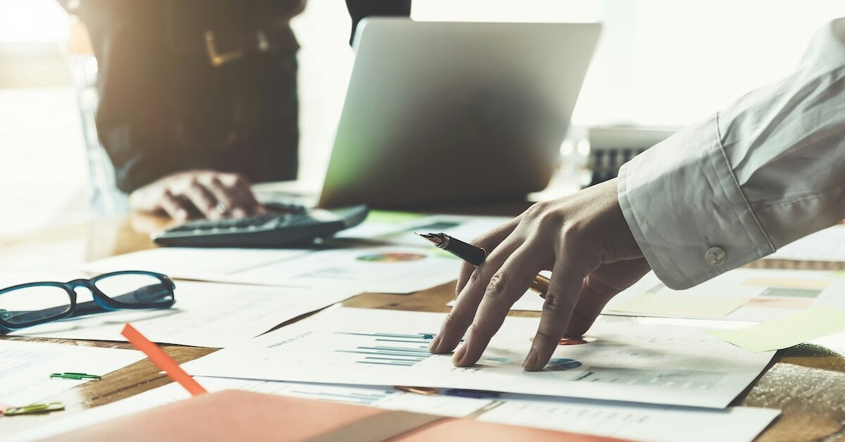 People researching on their computer and researching charts with data sourced from Crexi's Property Records