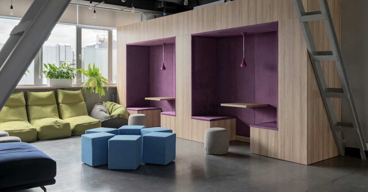 An open meeting space with cutout table and chairs, coaches, and plants