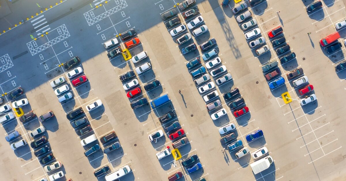 Parking lot overhead shot with several colorful cars in spots