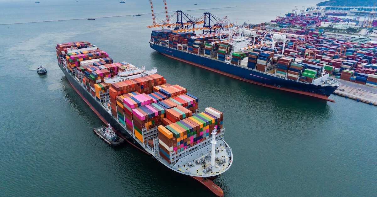 A pile of shipping containers atop a transport ship in Long Beach, CA's harbor
