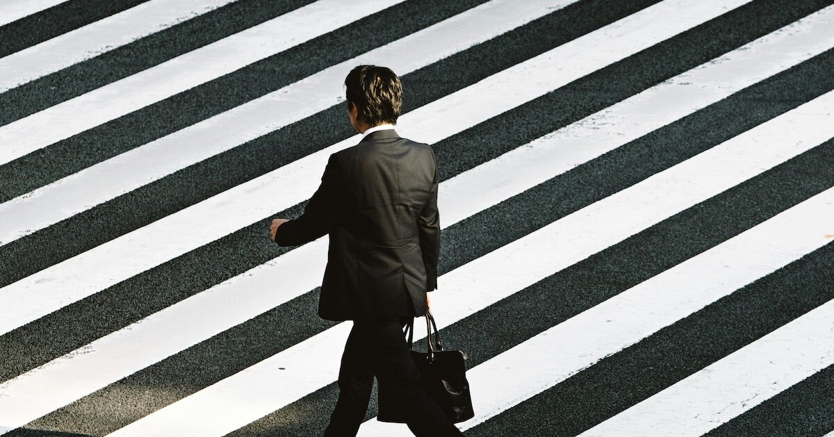 man crossing the street with a business briefcase
